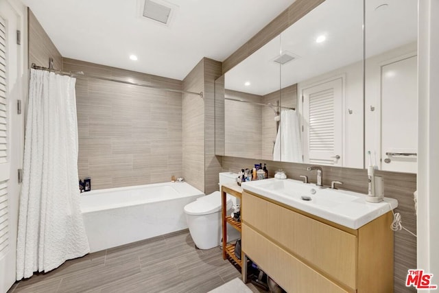 full bathroom with shower / bathtub combination with curtain, tile walls, vanity, and toilet