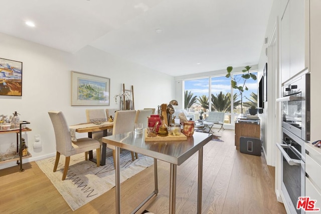 dining area with light hardwood / wood-style floors and floor to ceiling windows