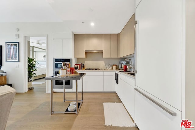 kitchen with double wall oven, gas cooktop, backsplash, and light hardwood / wood-style floors