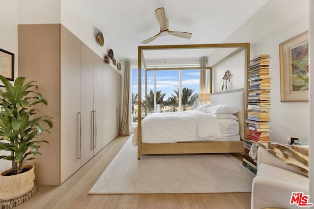 bedroom with ceiling fan, light wood-type flooring, and expansive windows