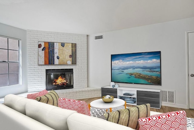 living room featuring hardwood / wood-style floors and a brick fireplace