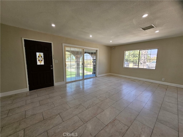 foyer featuring a textured ceiling and light tile patterned floors