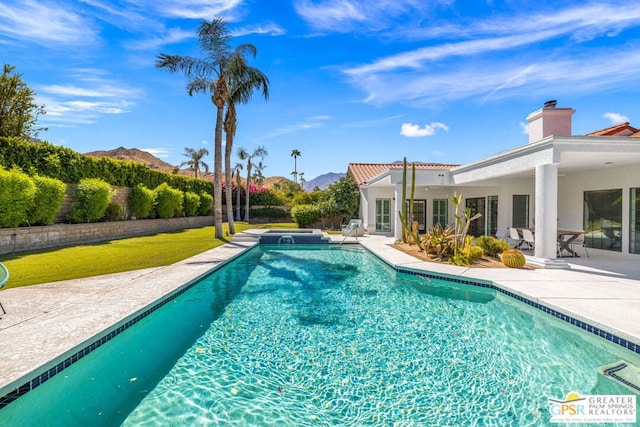 view of swimming pool with a mountain view, a patio, and an in ground hot tub