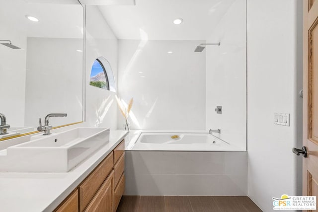 bathroom with hardwood / wood-style floors, vanity, and shower / bath combination