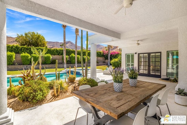 view of patio / terrace featuring a mountain view, a fenced in pool, and ceiling fan