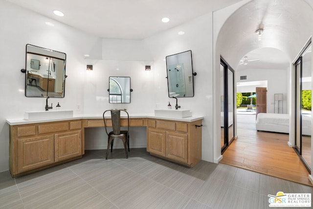 bathroom featuring ceiling fan, hardwood / wood-style floors, vanity, and vaulted ceiling