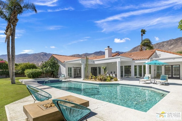 back of property featuring a mountain view and a patio