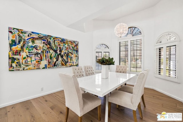 dining room with hardwood / wood-style flooring and a notable chandelier