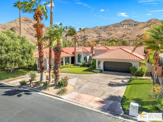 mediterranean / spanish-style home with a mountain view, a garage, and a front yard