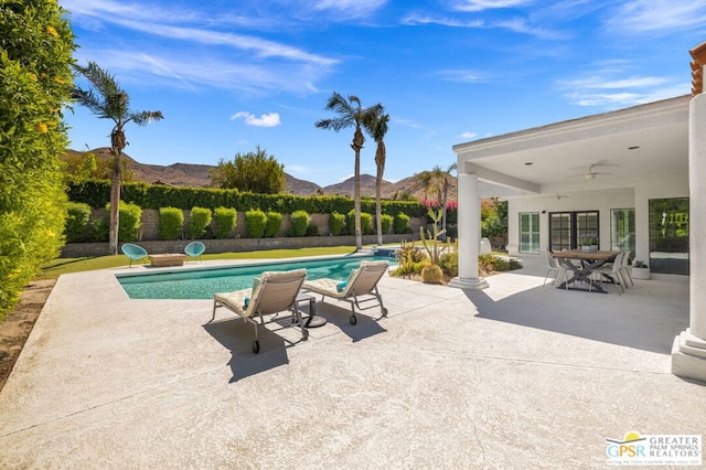 view of pool featuring a mountain view, ceiling fan, and a patio area