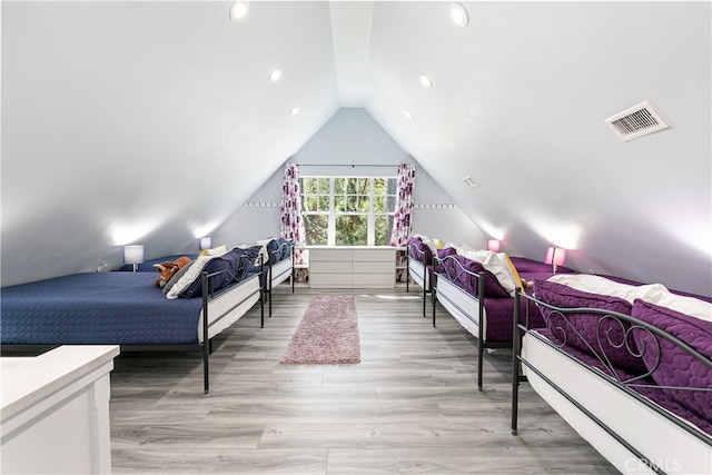 bedroom with light wood-type flooring and lofted ceiling