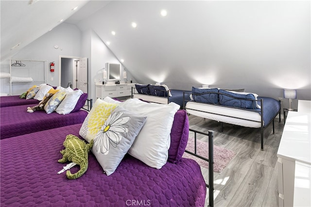 bedroom with light wood-type flooring and vaulted ceiling