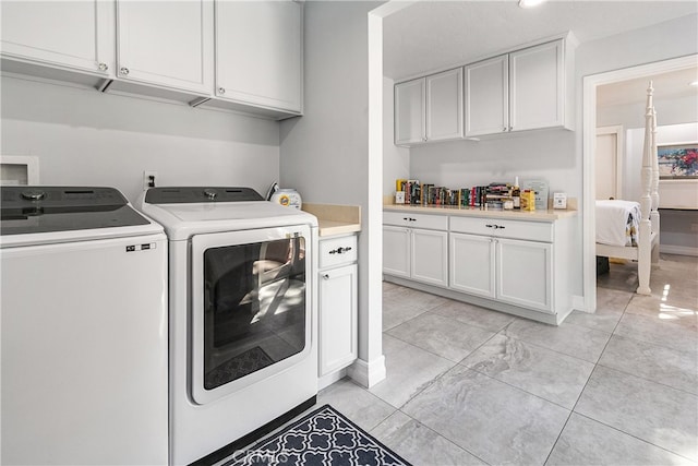 laundry area with washer and clothes dryer and cabinets