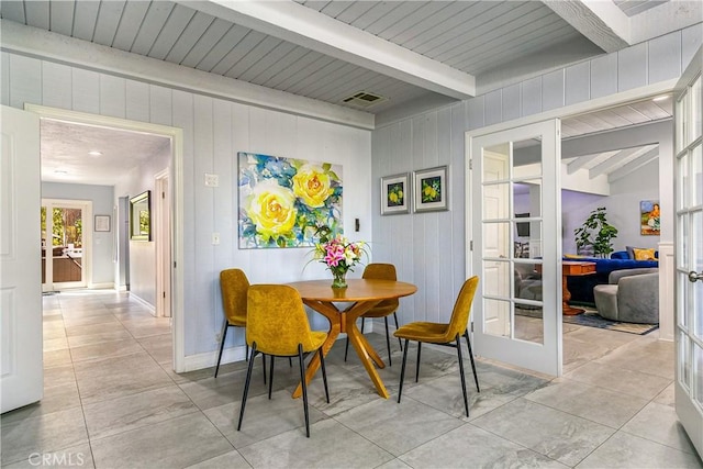 28281 Arbon Ln, Lake Arrowhead, CA 92352 - dining area with beam ceiling, french doors, wooden walls, light tile patterned floors, and baseboards