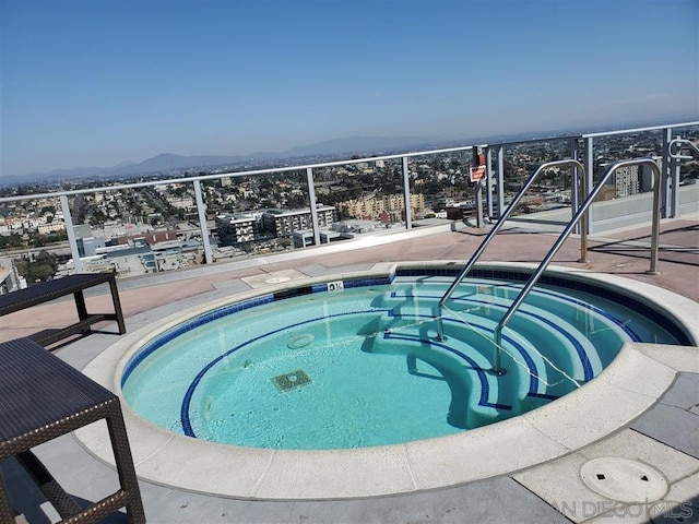 view of pool with a hot tub and a mountain view