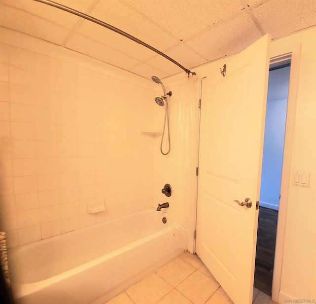 bathroom with a paneled ceiling, tile patterned floors, and shower / bathtub combination