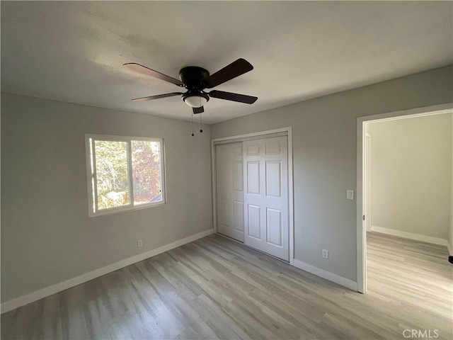 unfurnished bedroom with light hardwood / wood-style floors, ceiling fan, and a closet