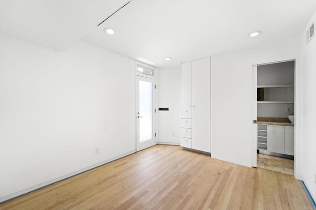 unfurnished bedroom with light wood-type flooring and a closet