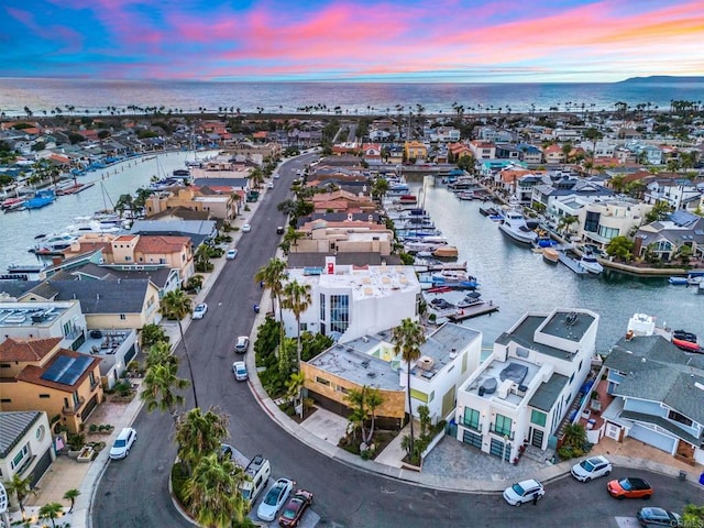 aerial view at dusk featuring a water view