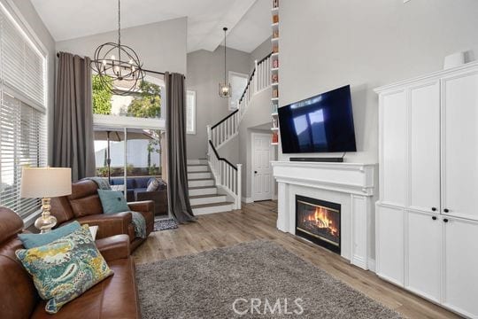 living room featuring hardwood / wood-style flooring, a high ceiling, and an inviting chandelier