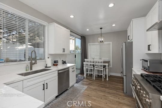 kitchen featuring dark wood-type flooring, appliances with stainless steel finishes, white cabinetry, and sink