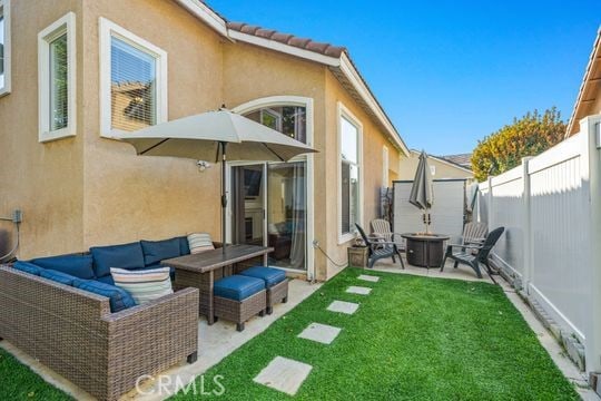 rear view of property with a patio area, an outdoor living space with a fire pit, and a yard