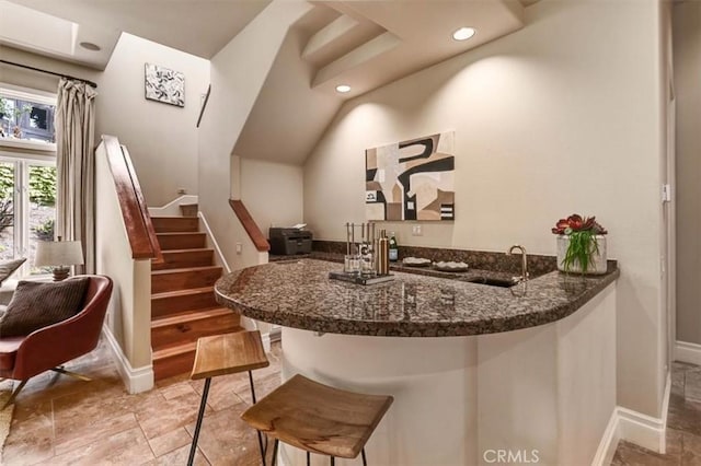 bar with dark stone countertops and sink