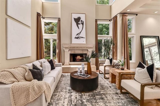 sitting room featuring a towering ceiling and a tile fireplace