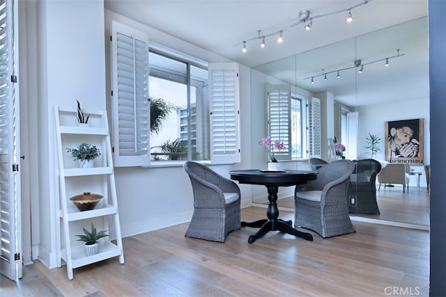 dining room featuring wood-type flooring and rail lighting