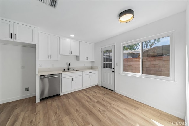 kitchen with sink, light wood-type flooring, white cabinetry, and stainless steel dishwasher