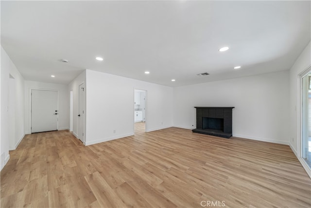 unfurnished living room featuring light hardwood / wood-style flooring and a fireplace