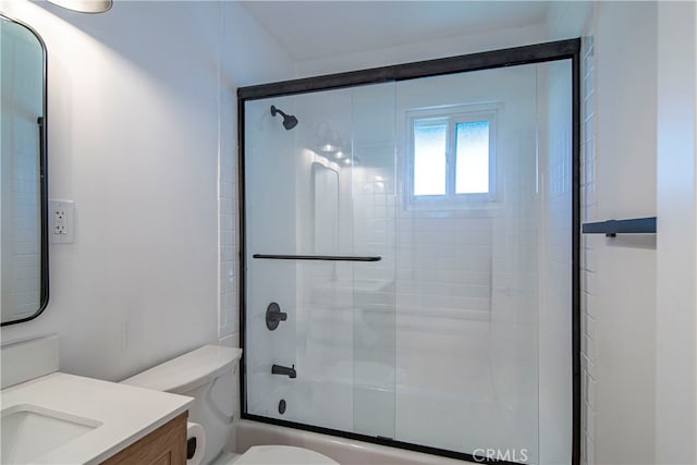 full bathroom featuring enclosed tub / shower combo, vanity, and toilet