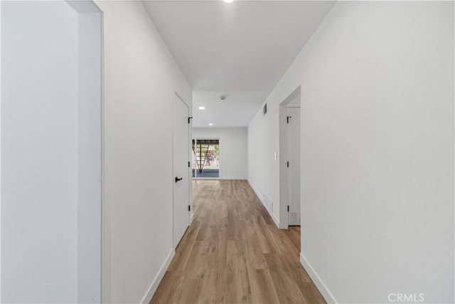 corridor with light hardwood / wood-style floors