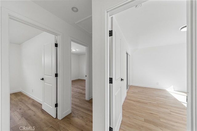 hallway with light hardwood / wood-style floors