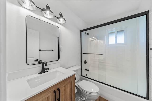 full bathroom featuring vanity, toilet, and combined bath / shower with glass door