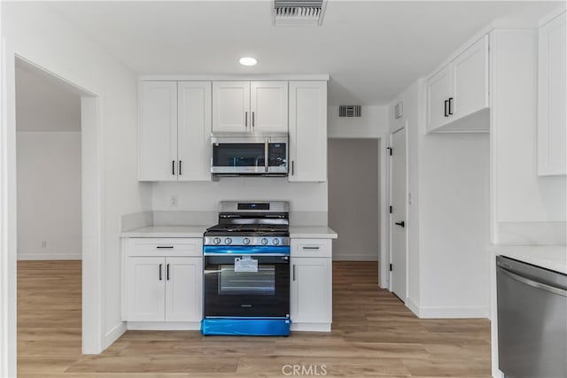 kitchen featuring light wood-type flooring, white cabinetry, and appliances with stainless steel finishes