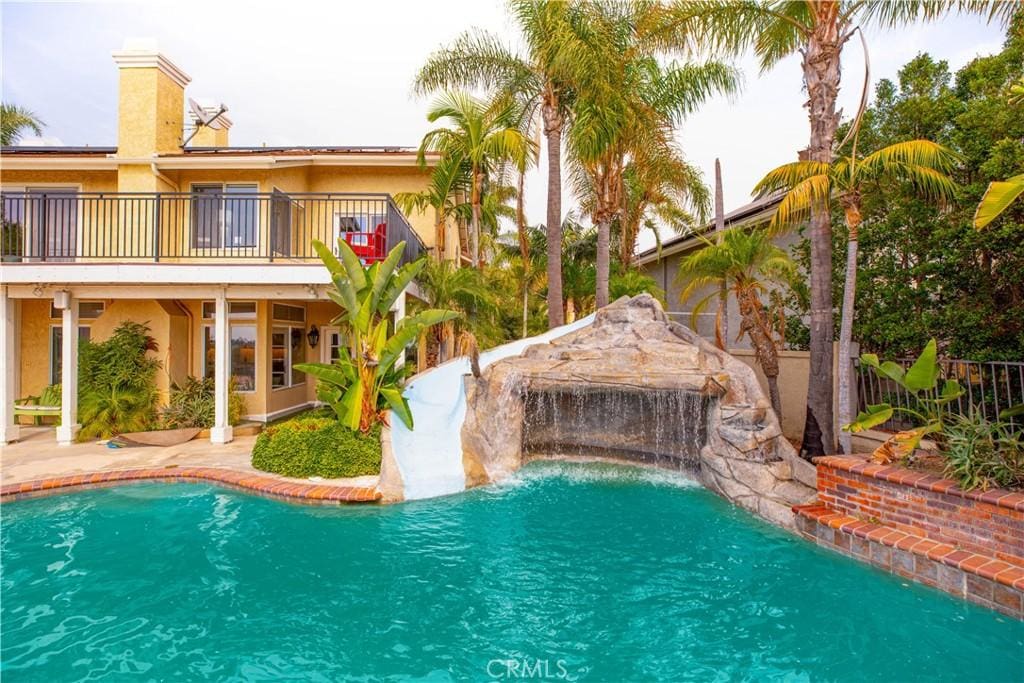 view of swimming pool with pool water feature