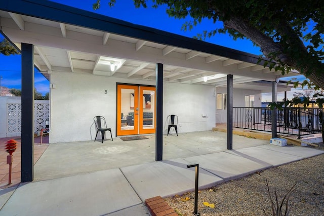 patio terrace at dusk featuring french doors