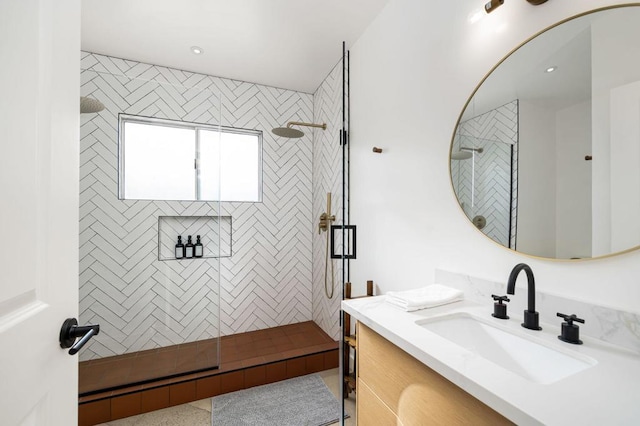 bathroom with vanity and a tile shower