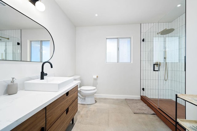 bathroom featuring vanity, a healthy amount of sunlight, an enclosed shower, and toilet