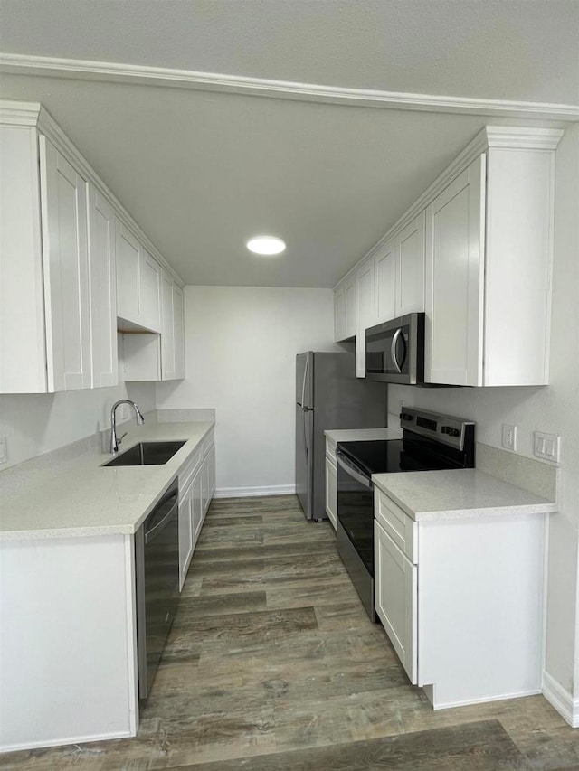 kitchen with dark hardwood / wood-style flooring, white cabinetry, appliances with stainless steel finishes, and sink