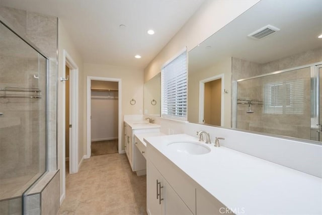 bathroom with vanity and a shower with door