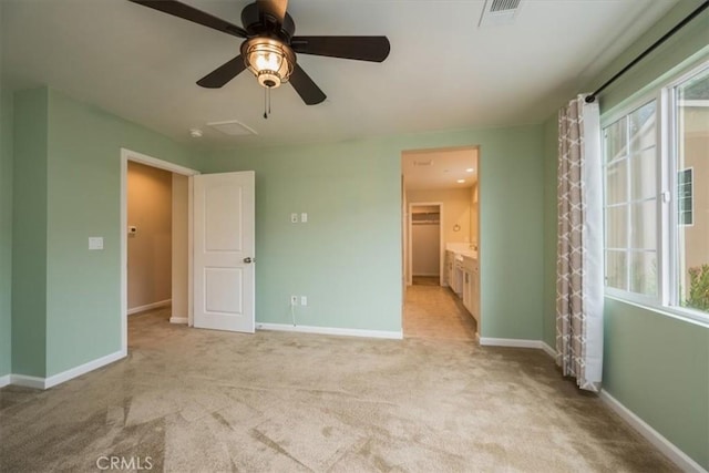 unfurnished bedroom featuring multiple windows, light colored carpet, and ceiling fan