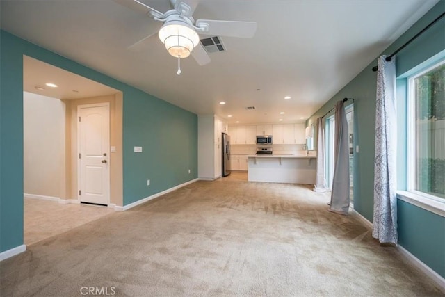 unfurnished living room with ceiling fan and light colored carpet