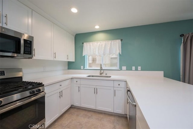 kitchen featuring sink, white cabinets, light tile patterned floors, and appliances with stainless steel finishes