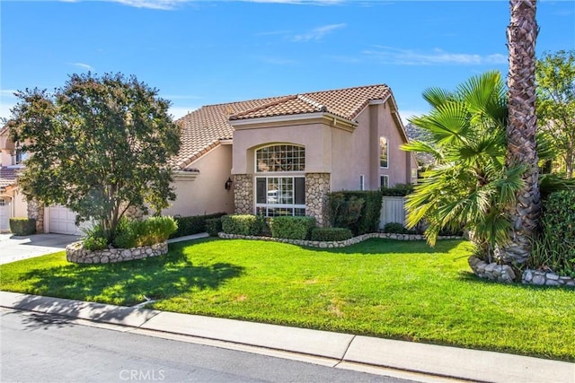 mediterranean / spanish home with a garage and a front lawn