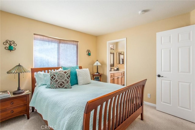 bedroom with light colored carpet, sink, and connected bathroom