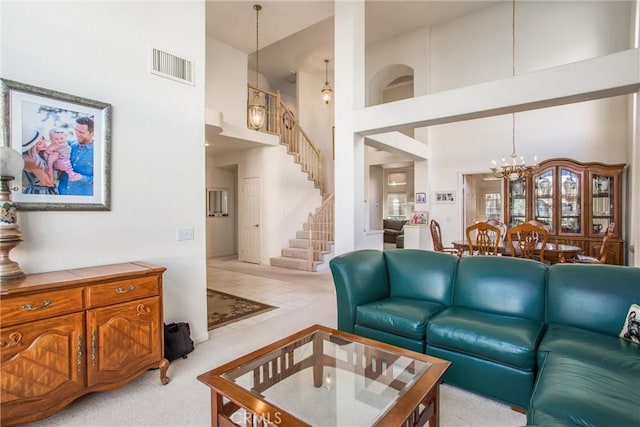 living room with light colored carpet, a high ceiling, and a chandelier