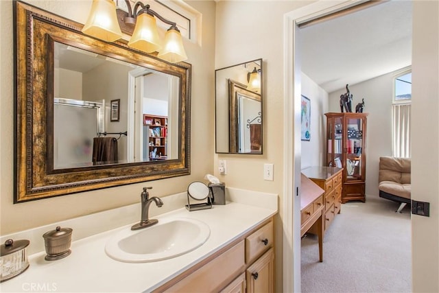 bathroom with vanity, a shower with shower door, and vaulted ceiling