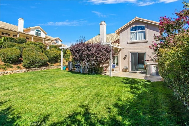 rear view of property with a yard and a patio